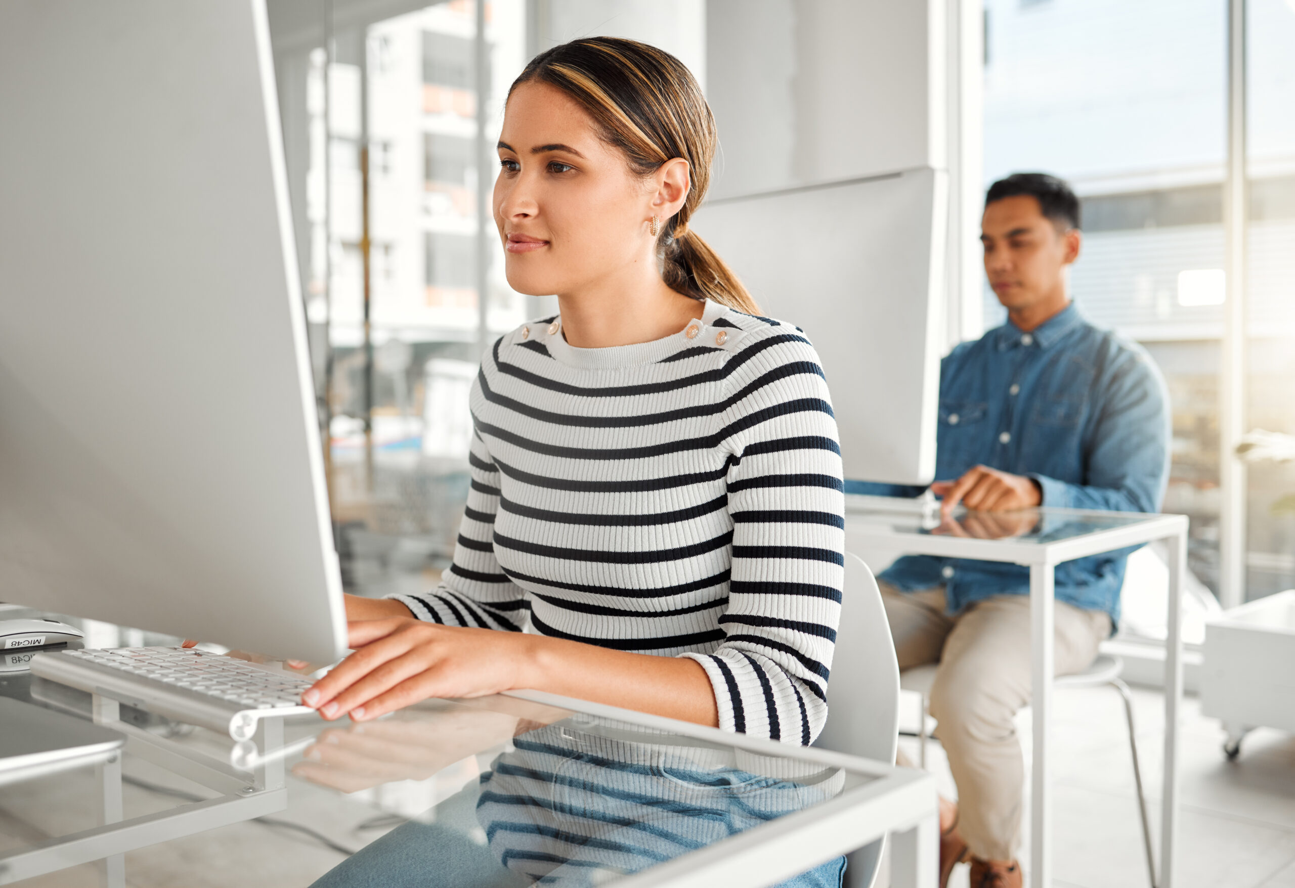 Businesswoman using a desktop computer in an office at work.