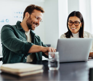 man and woman working together on laptop microsoft teams