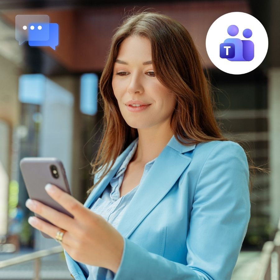 Woman in a light blue blazer reading a text on her phone outside an office building, Teams and chat icons.
