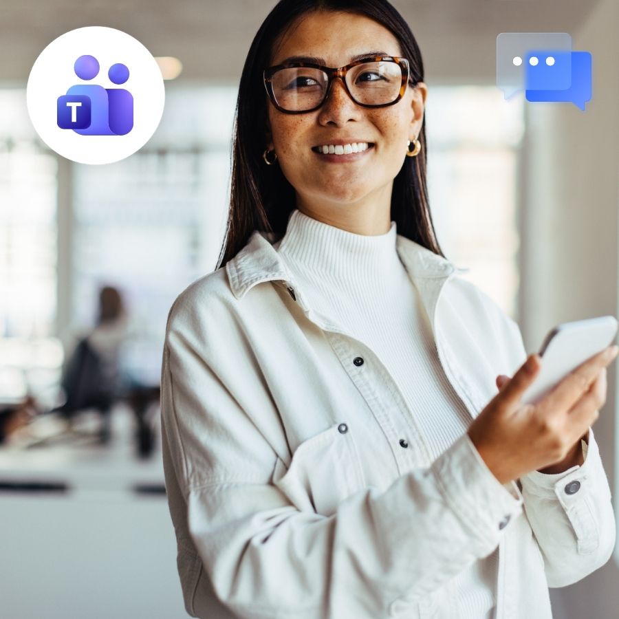 Smiling woman in glasses and white jacket holding a smartphone in an open office, Teams and chat icons.